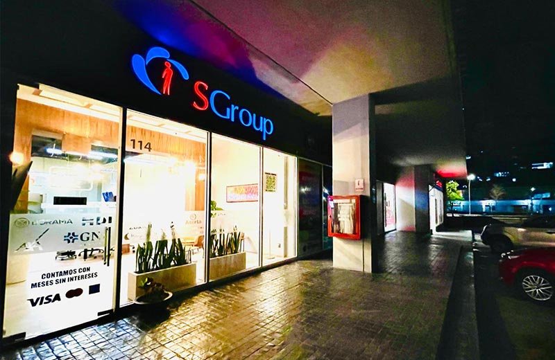 Sucursal SGroup Querétaro ubicada en una plaza comercial, con letrero iluminado, interiores modernos y logotipos de aseguradoras en los ventanales