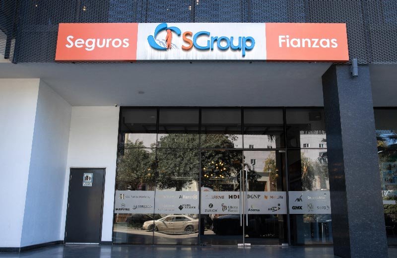 Fachada de la sucursal SGroup Tijuana en un edificio moderno, con letrero de 'Seguros y Fianzas', ubicada en Zona Río.